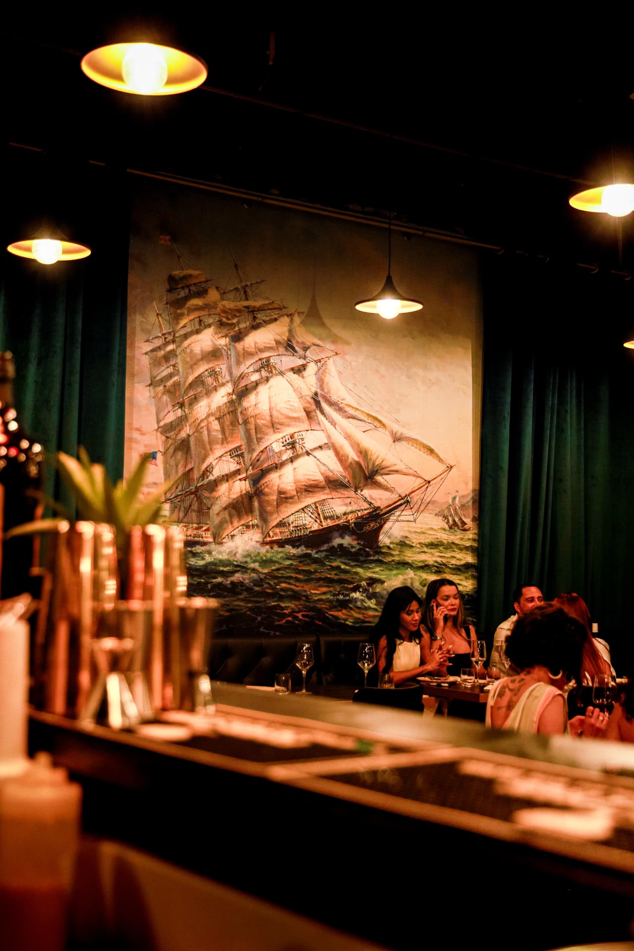 Guests dining beneath Atlantic sailing artwork inside Enora